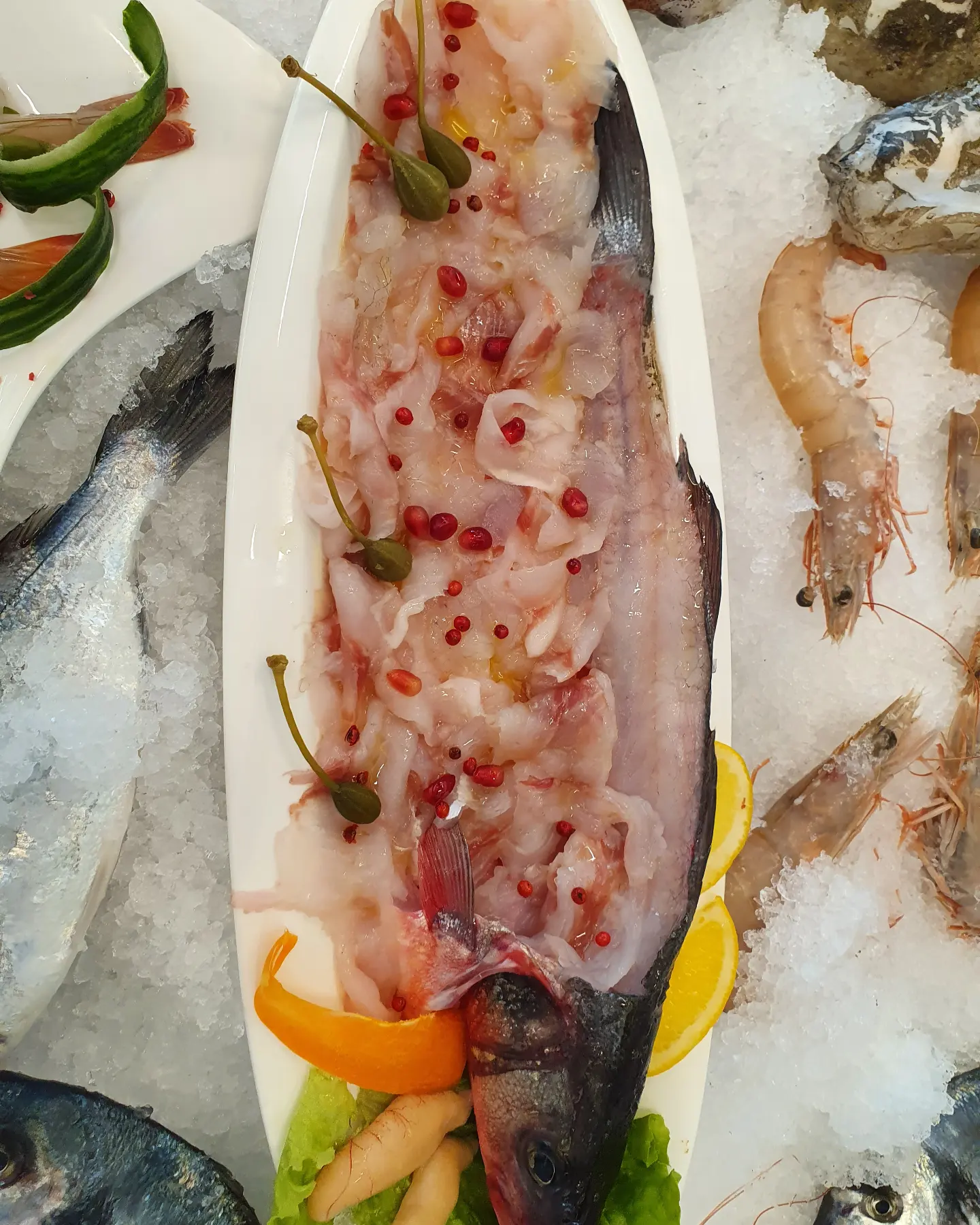 Fresh fish on ice with capers